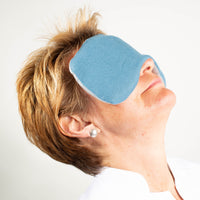 Frau mit Leinen-Augenmaske in taubenblau