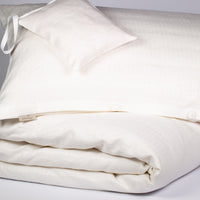 Bett mit weißer Bioleinenbettwäsche
