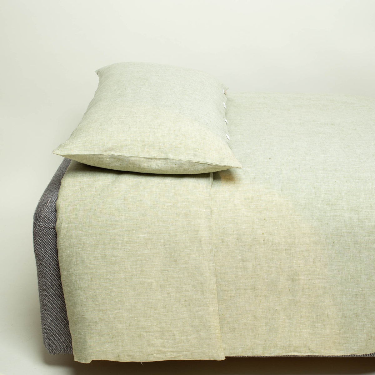 Bett mit grüner Bioleinenbettwäsche