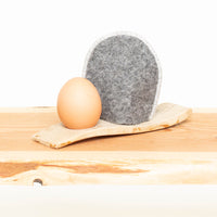 Eierwärmer mit Ei in grauer Wolle mit Rand creme