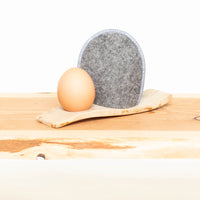 Eierwärmer mit Ei in grauer Wolle mit Rand blau